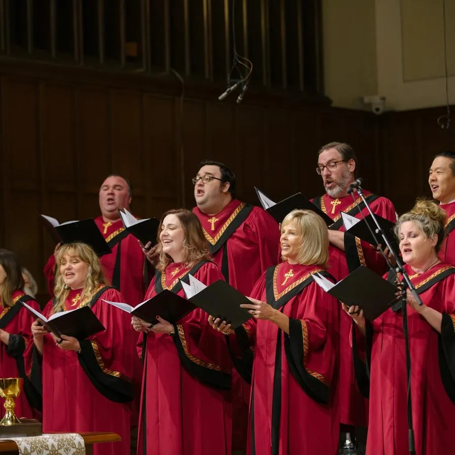Nine members of The Ensemble sing in red robes at the front of the SMCC sanctuary.
