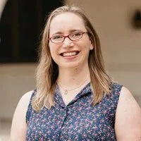 Natalie MacMillan, Director of Children's Ministries. A smiling young woman with red glasses.
