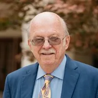 Rev. Dr. Ron C. White, Scholar in Residence. A smiling older gentleman in a blue suit.