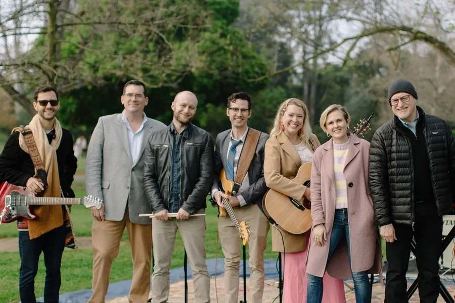 Members of the Virginia Road Band in coats and jackets stand with their instruments after an outdoor service.