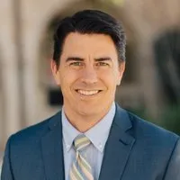 Rev. Dr. Erik Wiebe, Associate Pastor for Spiritual Formation & Pastoral Care. A smiling brow-haired man in a blue suit.